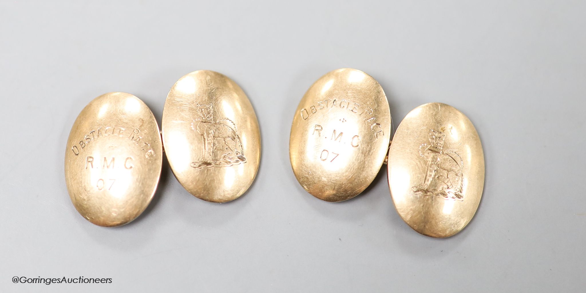A pair of early 20th century 9ct gold oval cufflinks, engraved with crest and date